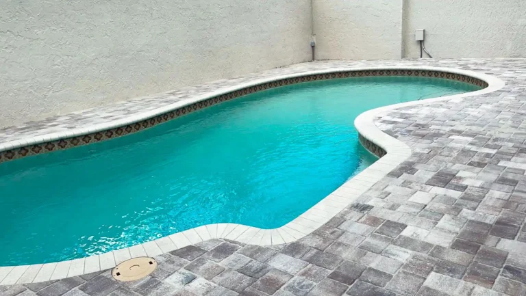 Custom curved pool deck remodel featuring slip-resistant cool pavers in Orlando, Florida — Rock Pavers.