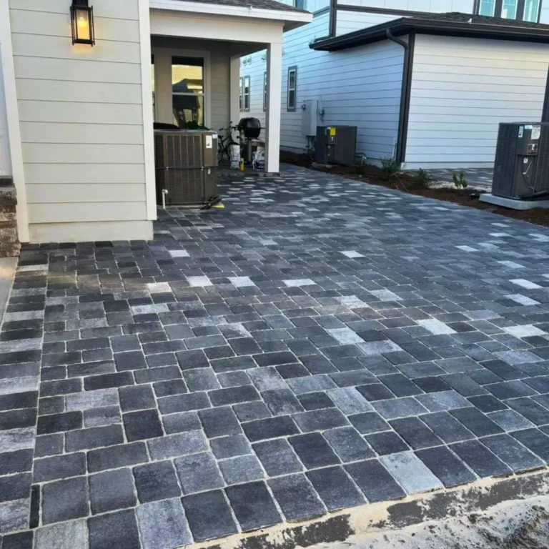 Modern garage driveway layout using contrasting dark and light paver stones in Orlando, Florida — Rock Pavers.
